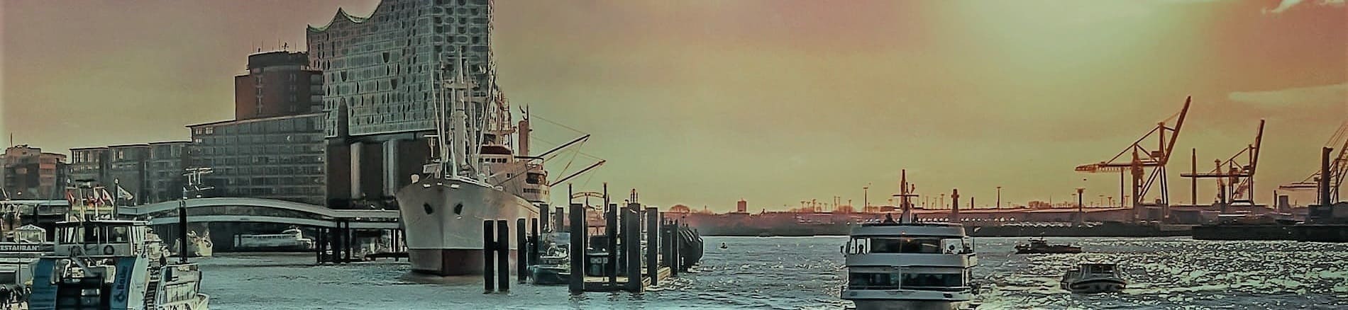 Die Elbe mit Blick auf das Schiff Cap San Diego, einst als Frachter und Passagierschiff auf der Südamerikaroute. Barkassen bei der Hafenrundfahrt, Hafenkräne zum Beladen von Containerschiffe und die Elbphilharmonie in Hamburg